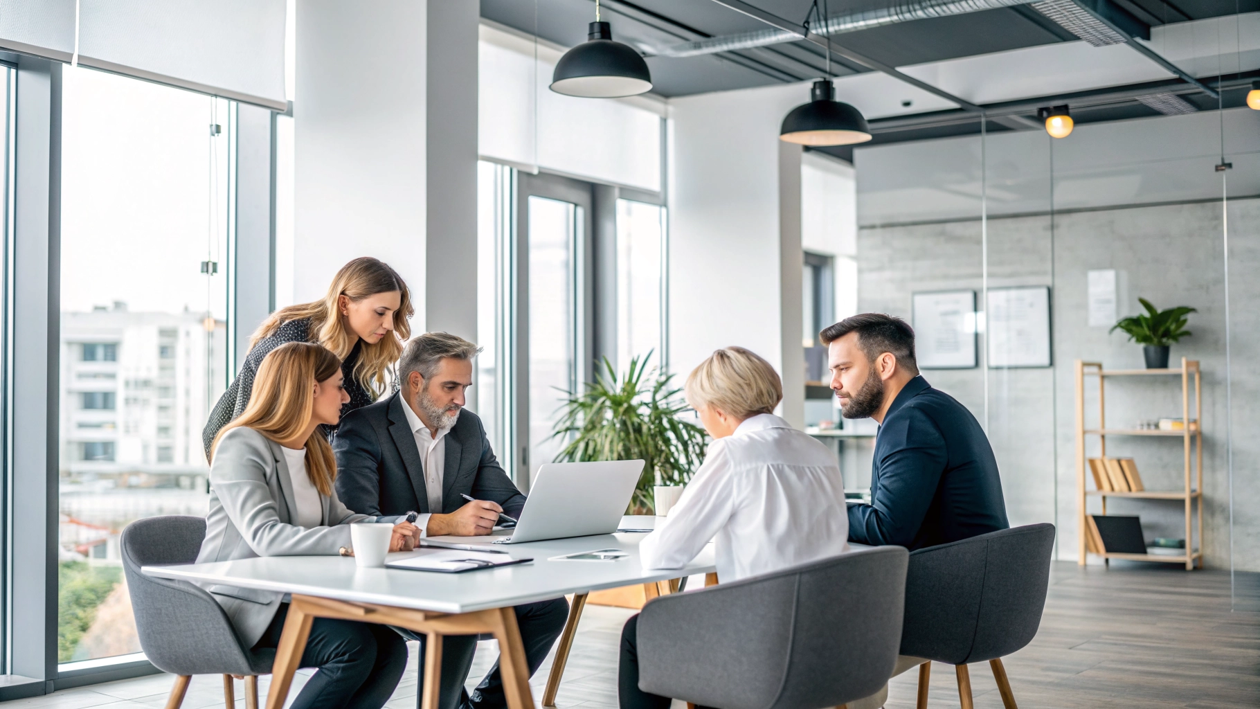 Equipo profesional adulto trabajando en una oficina moderna y luminosa, ambiente colaborativo y serio.